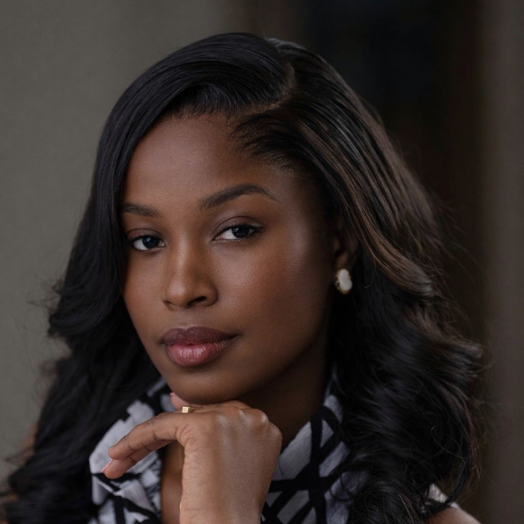Woman wearing a black and white patterned scarf with a neutral background